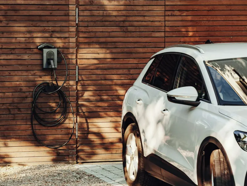 Borne de recharge murale à côté d’une voiture électrique